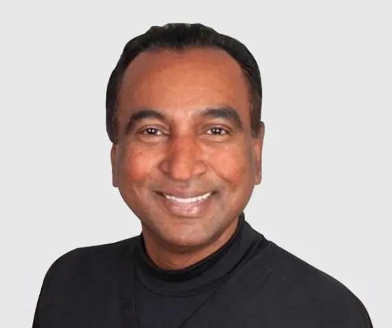 A man in black shirt smiling for the camera.